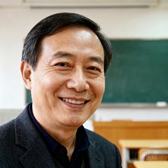 上海某高校信息中心主任张教授的半身照，在教室中微笑